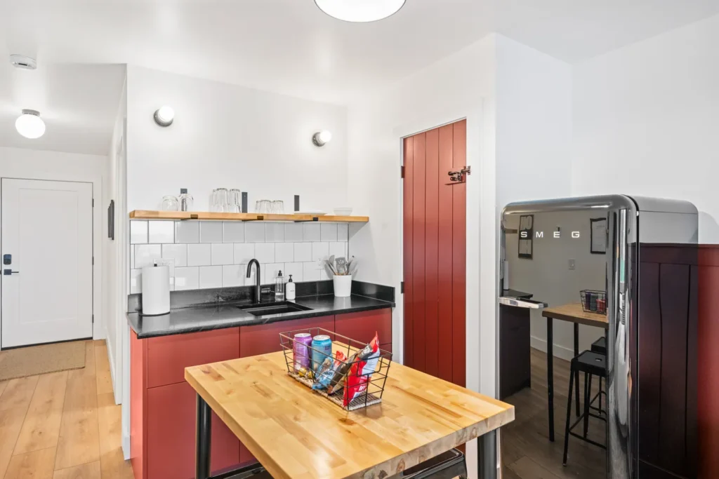 Modern kitchen with red cabinets and black fridge