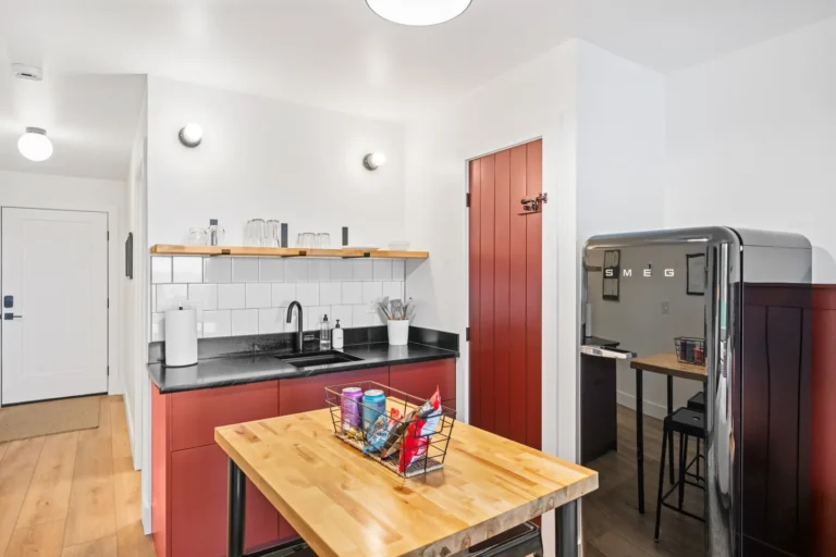 Modern kitchen with red cabinets and black fridge