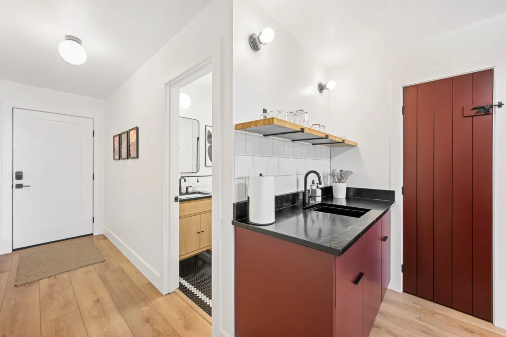 Modern kitchenette with red cabinets and black countertop