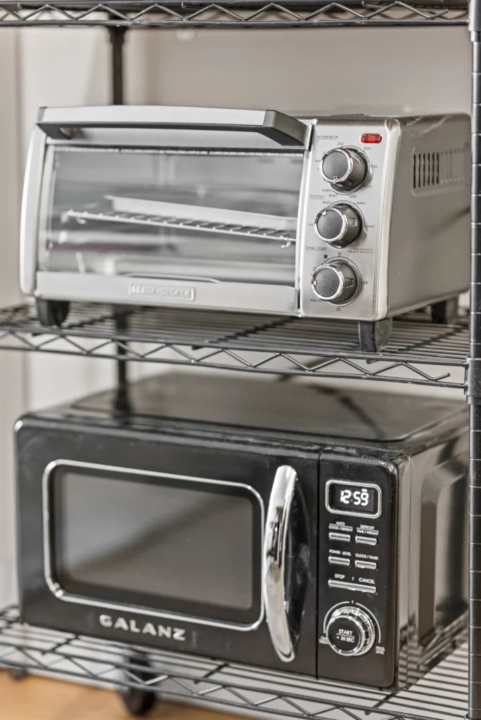 Toaster oven and microwave on metal kitchen shelf