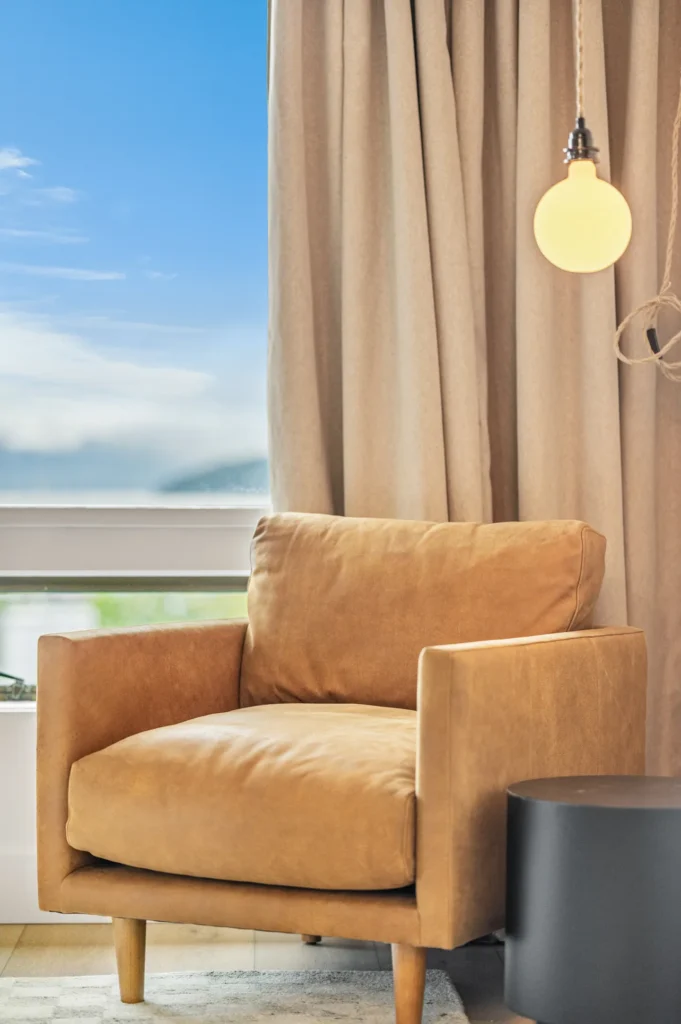 Cozy brown armchair by window with curtain