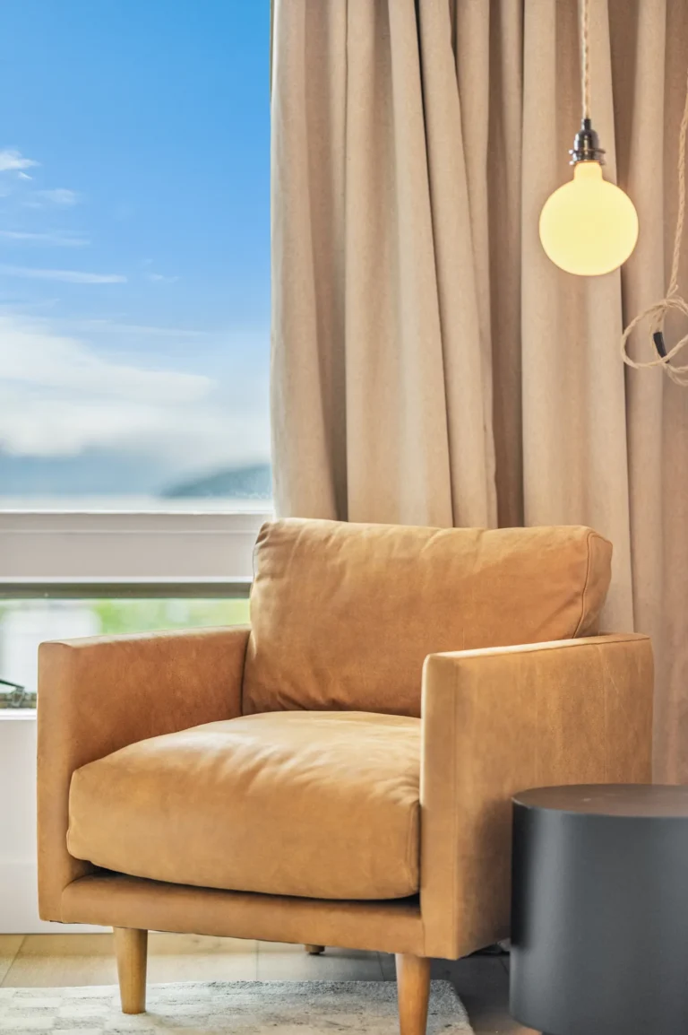 Cozy brown armchair by window with curtain