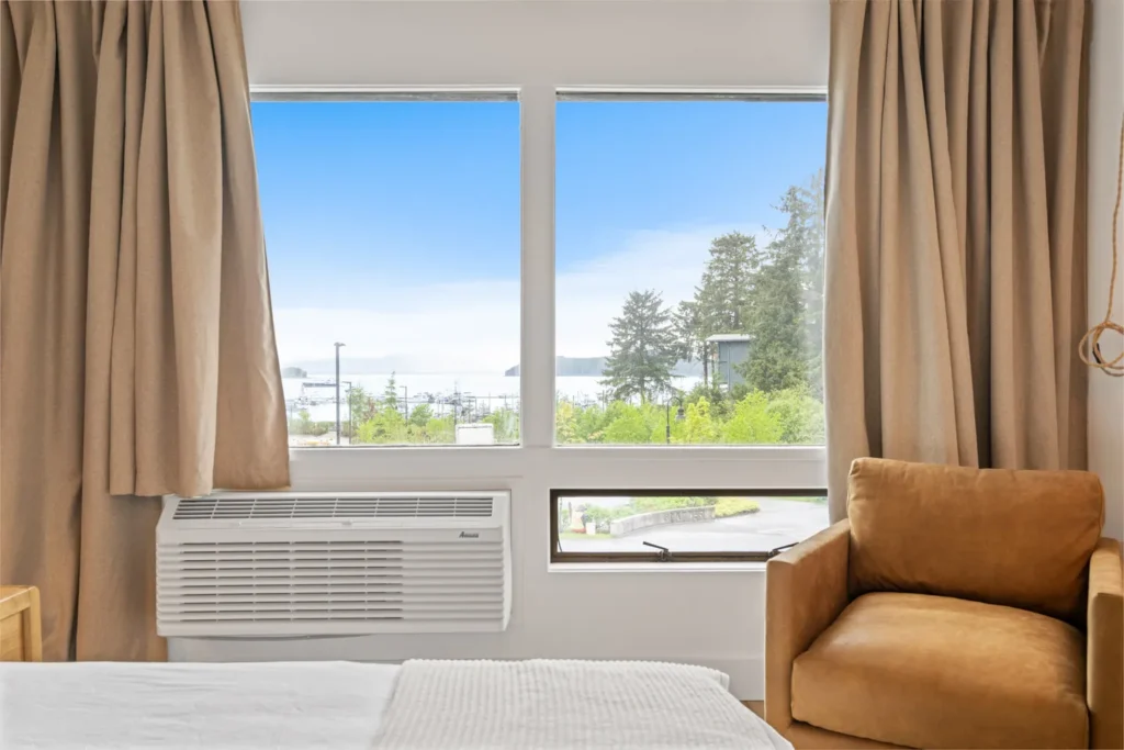 Bedroom window view of trees and ocean