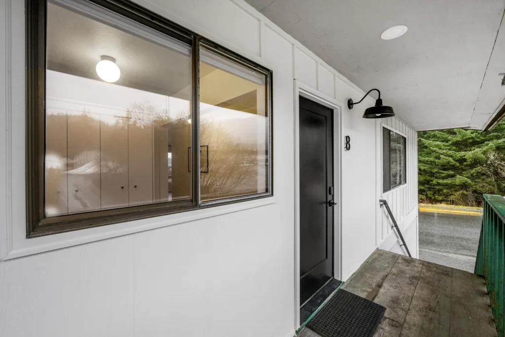Modern white apartment exterior with black door