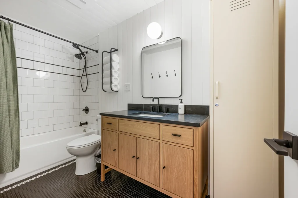 Modern bathroom with wood vanity and tiled shower.