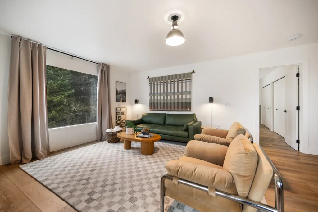 Modern living room with green sofa and large window