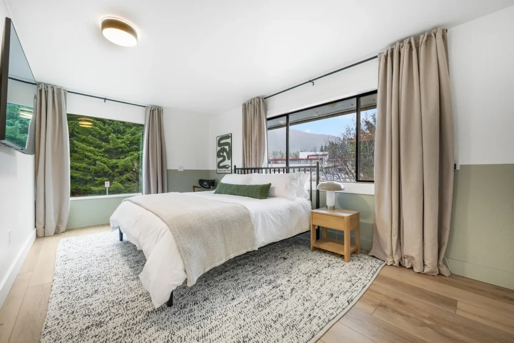 Modern bedroom with large windows and cozy decor