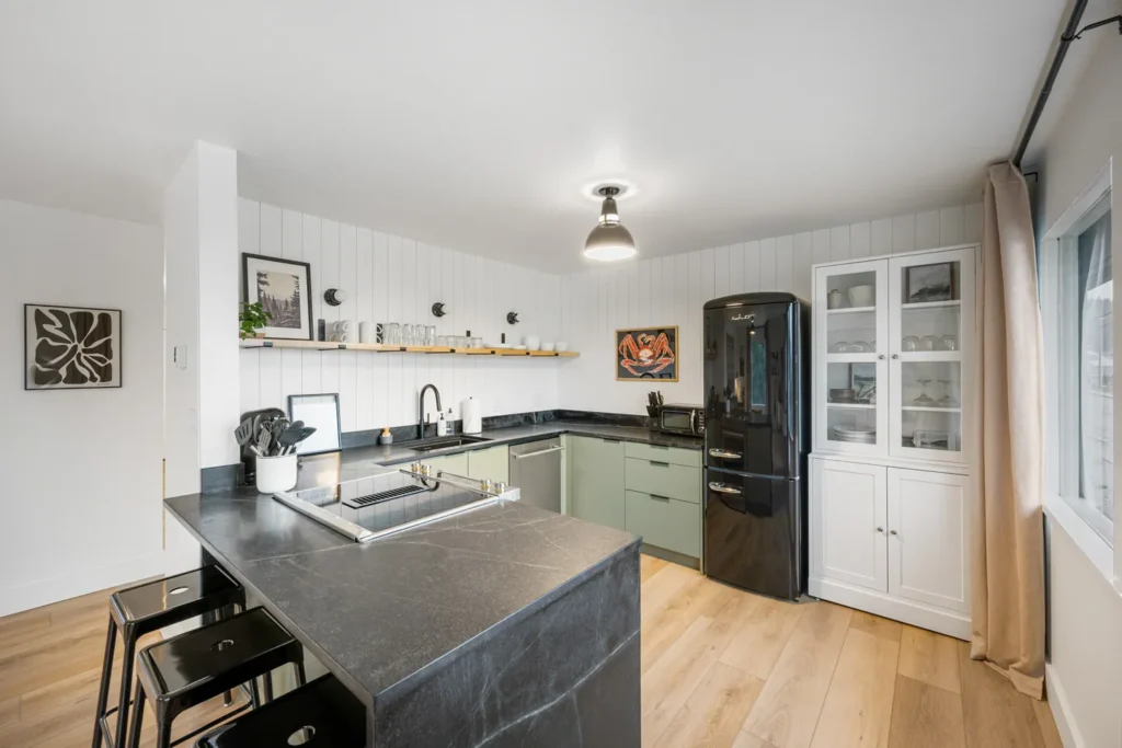 Modern kitchen with black countertops and retro fridge