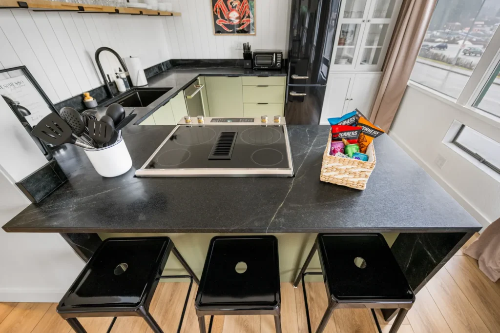 Modern kitchen with black countertop and bar stools
