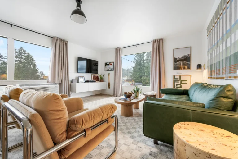 Modern living room with green sofa and large windows