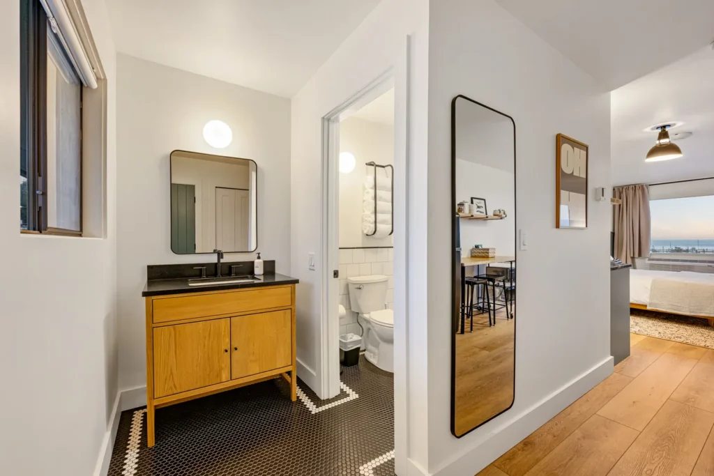 Modern bathroom with wooden vanity and bedroom view