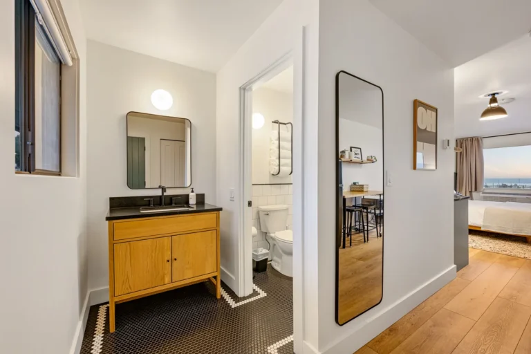 Modern bathroom with wooden vanity and bedroom view
