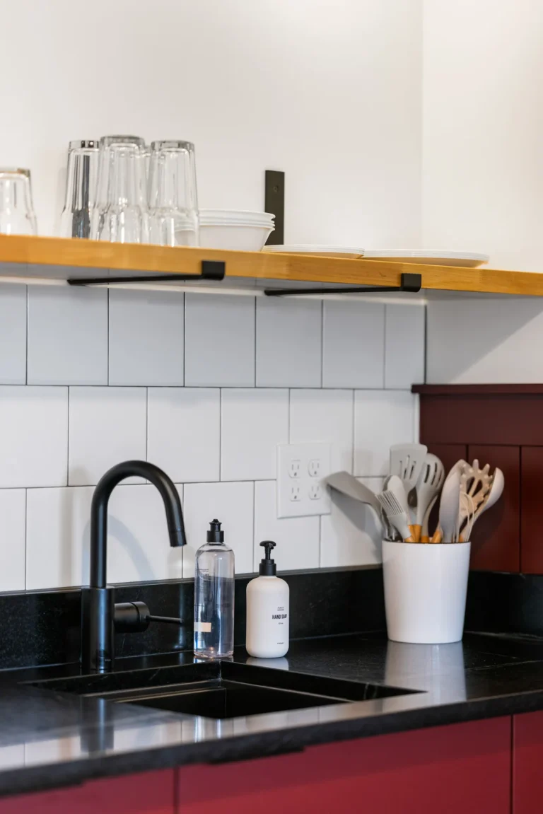 Modern kitchen sink with utensils and open shelves