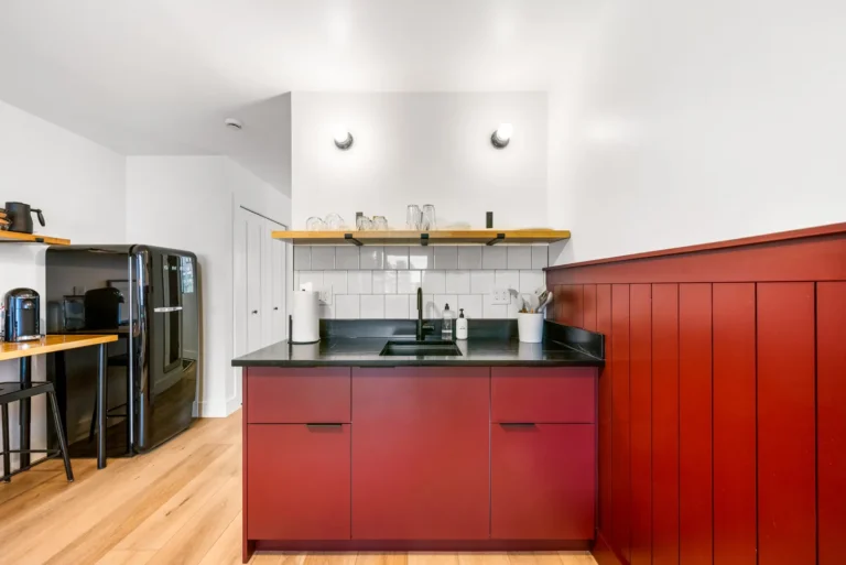 Modern kitchen with red cabinets and black countertop