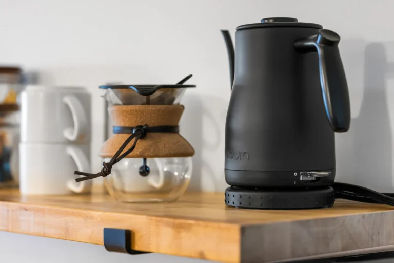 Black electric kettle and coffee maker on shelf
