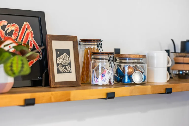 Wooden kitchen shelf with jars and framed art