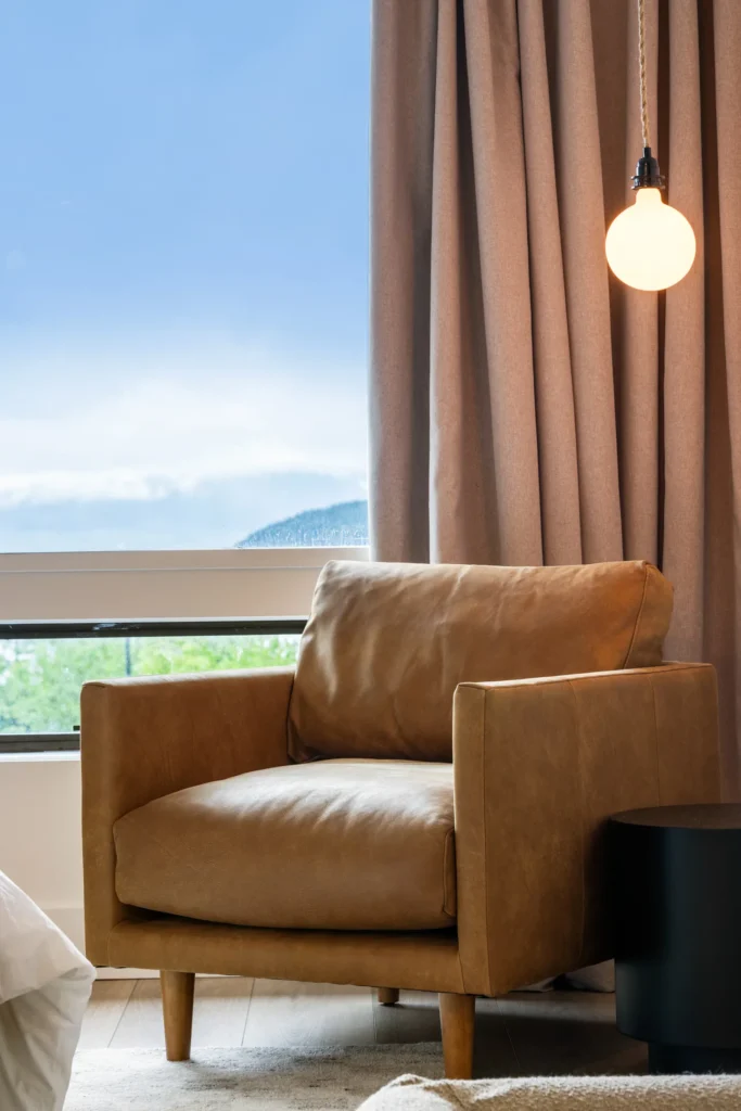 Modern leather armchair beside window and lamp