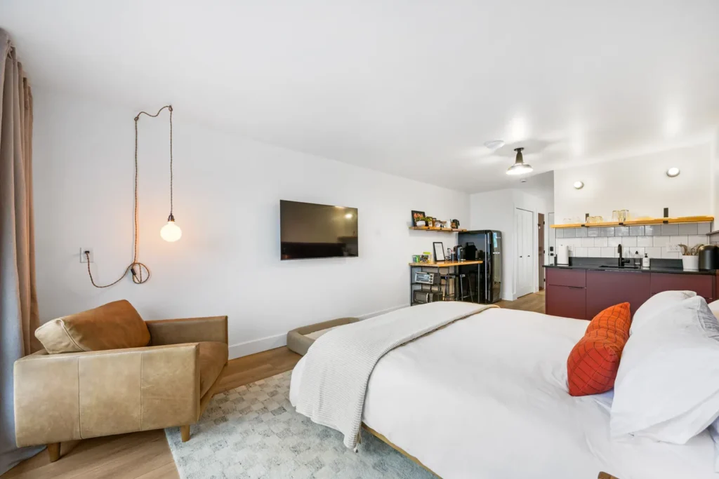 Modern studio bedroom with kitchenette and cozy decor