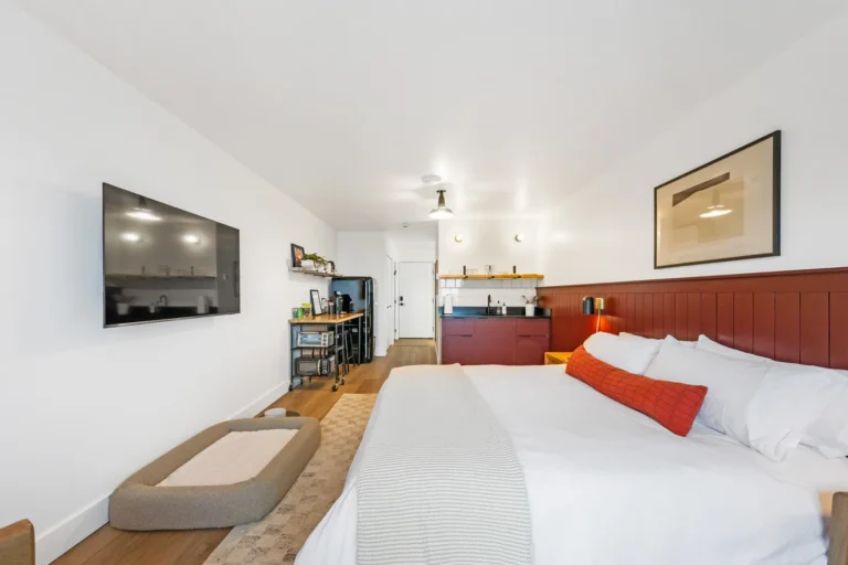 Modern hotel room with bed and kitchenette