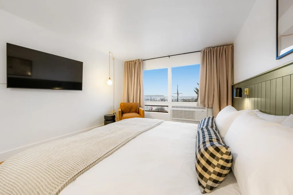 Cozy hotel room with bed and ocean view.