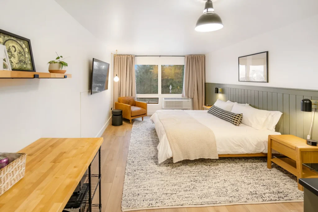 Modern cozy bedroom with large bed and window view