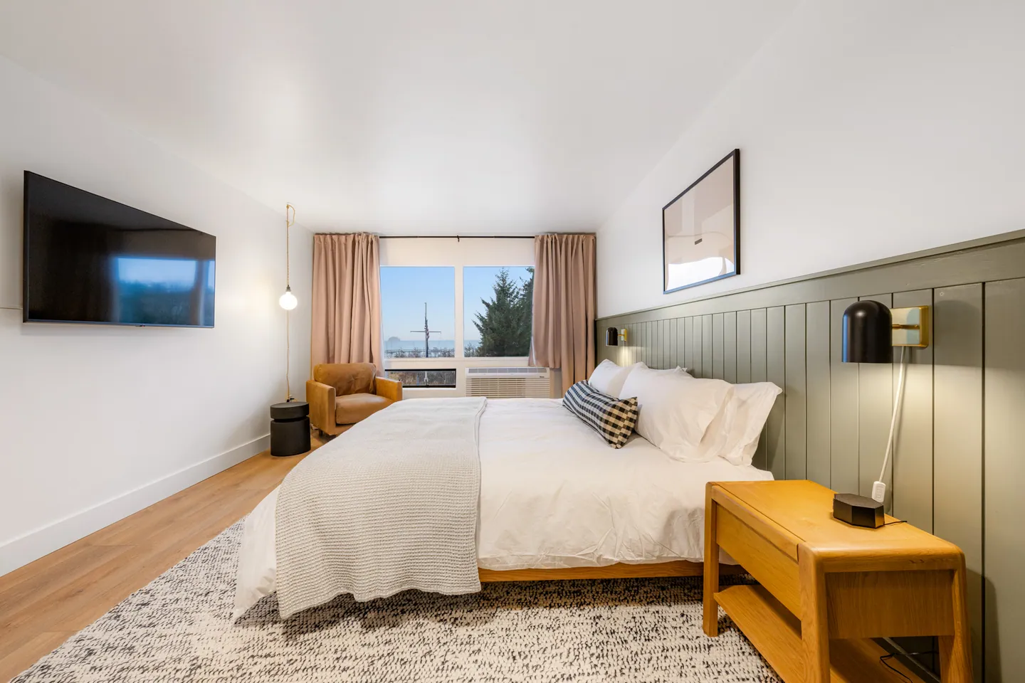 Modern bedroom with large bed and window view