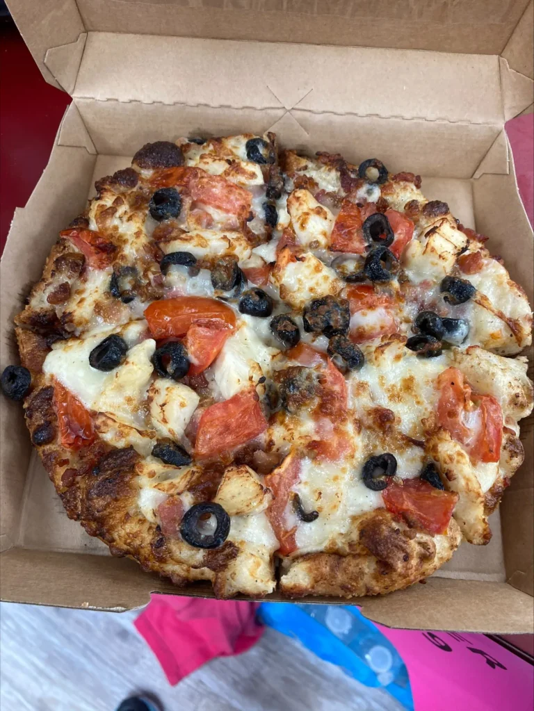 Fresh pizza with cheese, olives, and tomatoes