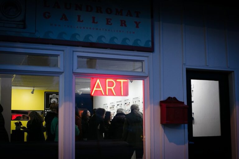 People viewing art inside laundromat gallery